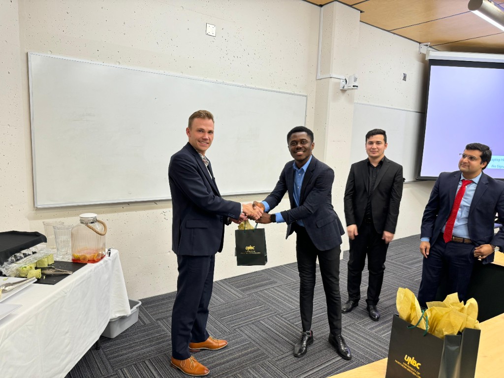 George Amoako receiving a gift bag at a UNBC Investment Club event